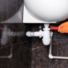 Rohrleitung und Siphon unter einem Waschbecken werden repariert